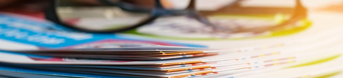 Zoomed in image of a stack of file folders with a pair of glasses on top