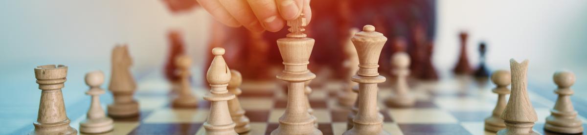 Chess board and a hand moving a piece