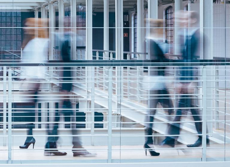 Blurred image of business people walking in an open indoor space