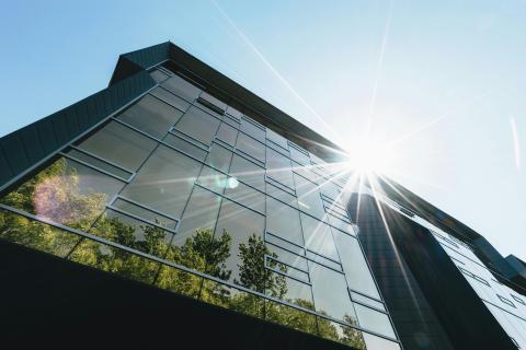 a building with the reflection of trees in the windows