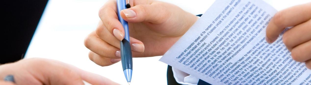 Hands holding pen and papers