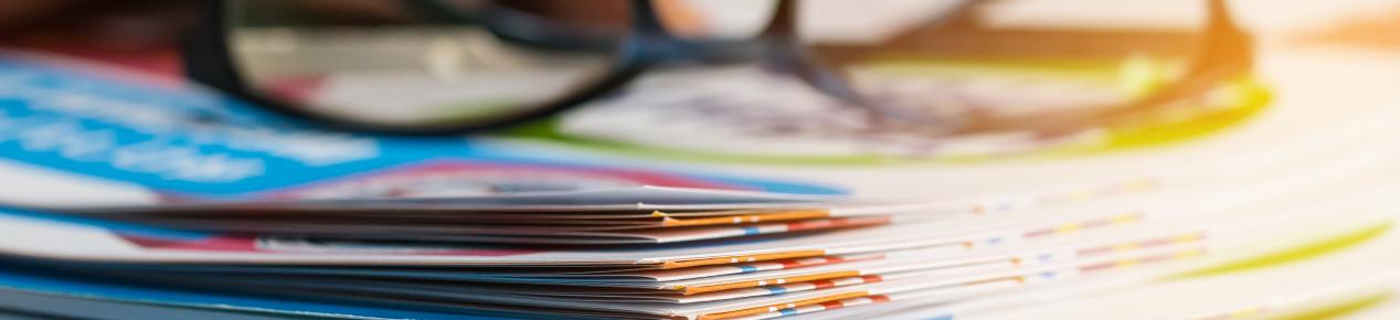 Zoomed in image of a stack of file folders with a pair of glasses on top
